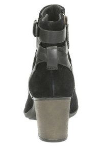 Musta mokkanahka naisille tarkoitettu nilkkuri, jossa on paksu ruskea korokepohja, nahkahihnat ja sivuvetoketju, nähtynä takaa.