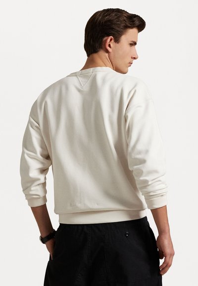 Lichtbeige crewneck sweatshirt met geribbelde boorden en zoom. Zachte textuur, eenvoudig ontwerp, met een relaxte pasvorm en geen zichtbare patronen of accenten.