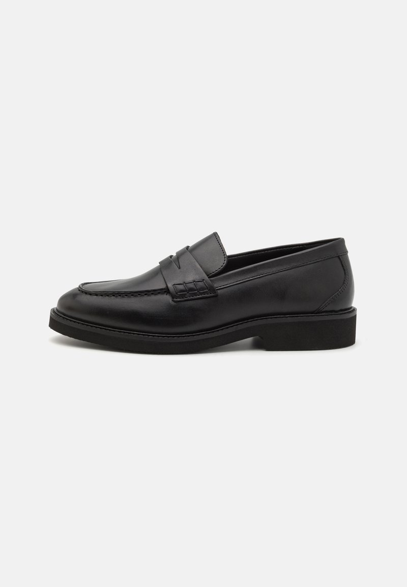 Sorte skinnloafers med en glatt overflate, preget av en vevd detalj over vampen og en lav gummisåle.