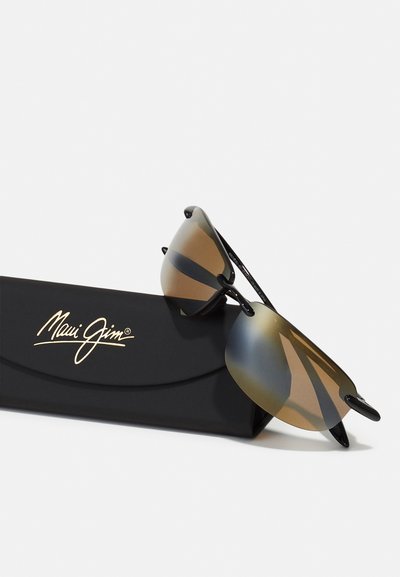 Occhiali da sole Maui Jim con montatura nera, lenti marroni sfumate e un design avvolgente elegante, riposti in un astuccio nero con logo.