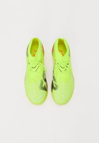 Bottes de football jaune vif avec une tige texturée, des accents noirs et des détails roses. Comprend des lacets et un design élégant et aérodynamique.