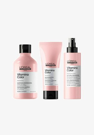 Three pink hair care products with black accents: a round shampoo bottle, a squeeze conditioner tube, and a spray treatment bottle, all branded.