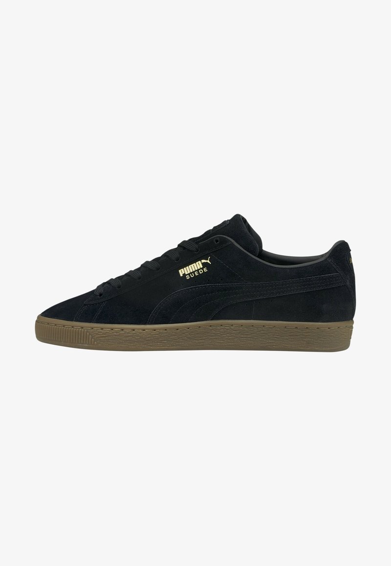 Baskets basses Puma en daim noir avec semelle en gomme, logo Puma doré et détails en daim sur le côté.