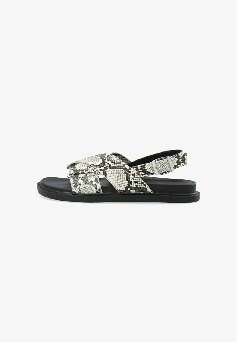 Snake print sandals featuring a cross strap design in black and grey with a flat black sole and an adjustable buckle on the heel strap.