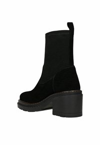 Czarne botki zamszowe na masywnym obcasie, z zaokrąglonymi noskami, widocznym przeszyciem oraz teksturowaną podeszwą dla lepszej przyczepności.