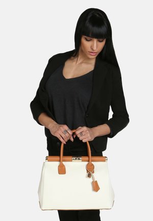 Sac à main structuré blanc avec des accents en cuir beige et un charm en forme de cadenas. Dispose de poignées arrondies et d'un détail de fermoir en argent, fabriqué à partir d'un matériau texturé.