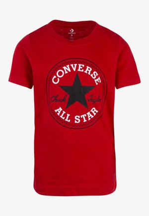 T-shirt en coton rouge avec un graphique noir rond comportant une étoile et le texte "Converse All Star" en blanc et noir, manches courtes et col rond.