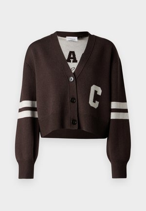Cardigan court marron avec un col en V, des boutons noirs et des rayures blanches sur les manches. Affiche une grande lettre "C" en crème contrasté.