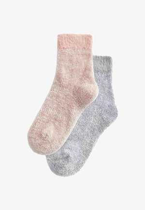 Two pairs of cozy socks: one in light pink and one in light gray. Both have a fluffy texture and a simple, solid design.