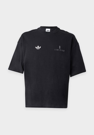 Μαύρο t-shirt με κοντά μανίκια, μικρό λευκό λογότυπο Adidas trefoil στο αριστερό στήθος και κείμενο "I AM ISIGO" στο δεξί στήθος.