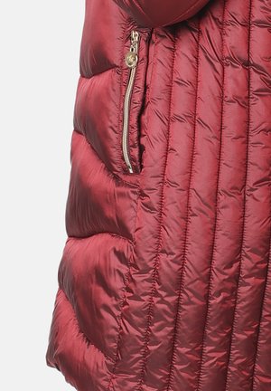 Chaqueta de plumas carmesí con textura acolchada, bolsillo lateral con cremallera y acabado brillante. Presenta costuras verticales y un diseño acolchado.