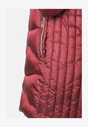 Chaqueta de plumas carmesí con textura acolchada, bolsillo lateral con cremallera y acabado brillante. Presenta costuras verticales y un diseño acolchado.