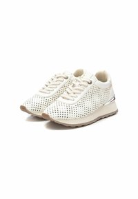 Zapatos deportivos blancos con parte superior perforada, suela de goma beige y acentos plateados contrastantes. Cuenta con puntera redondeada y diseño de cordones en la parte frontal.
