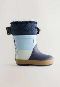 Botas de lluvia de goma azules con un cuello de tela acolchada en color marino, que presentan un personaje de dibujos animados y una suela texturizada para mayor agarre. Acento en marrón claro en la parte inferior.