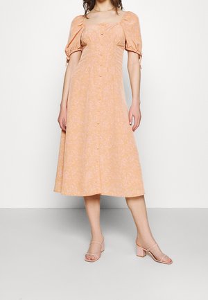 Vestido midi color durazno con mangas abullonadas, escote cuadrado y cierre de botones en el frente. Presenta un estampado floral paisley y una textura de tela suave.
