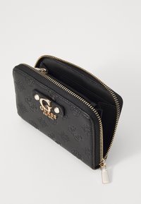 Portofel negru cu fermoar, având un model embosat cu logo, accesorii aurii și un logo GUESS proeminent în față. Două compartimente vizibile.