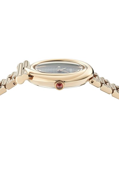 Aranyszínű karóra, kerek tok, tiszta üveg és texturált fekete számlap. A szíjon szív alakú láncszemek, és piros dísz a koronán.