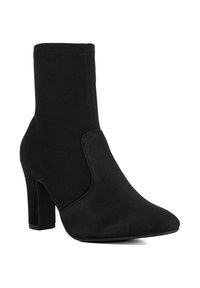 Black ankle boot made of soft fabric with a high heel, pointed toe, and side panel detail, featuring a sleek, seamless design.