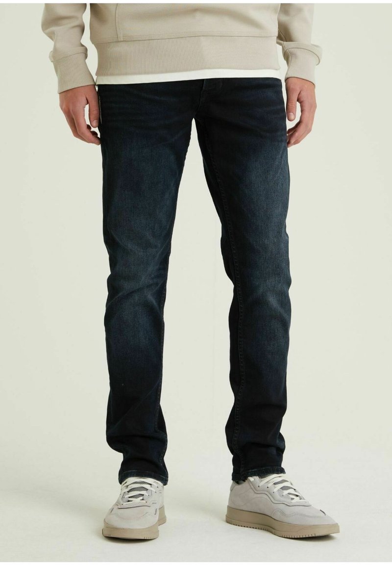 Jeans in denim blu scuro, slim fit, con un classico design a cinque tasche. Il tessuto ha una consistenza liscia con una leggera scoloritura sulle ginocchia.