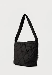 Κουβερτισμένη μαύρη τσάντα ώμου με μαλακή υφή, ρυθμιζόμενη ζώνη και κλείσιμο με κορδόνι. Ορθογώνιο σχήμα με μαξιλαρωμένες πλευρές.
