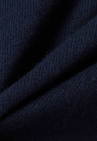 Marineblauer Strickstoff mit subtiler Rippstruktur, der weiche Fasern und einen sanften Fall zeigt und seine Wärme und Dicke betont.