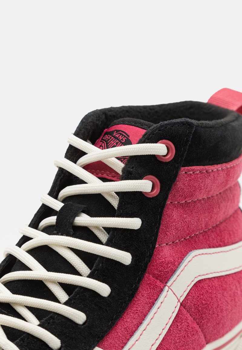 Zapatillas altas que presentan una parte superior de ante rosa con acentos en negro, cordones blancos y un logo rosa en la lengua. Incluye rayas blancas en contraste.