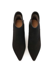 Botines de ante negros hasta el tobillo con punteras afiladas y tacones bajos; cuentan con cremalleras laterales y una textura suave y mate.