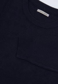 Suéter de punto azul marino con cuello redondo y acabado texturizado, que cuenta con un bolsillo tipo parche en la parte delantera. La etiqueta dice "DAN JOHN."