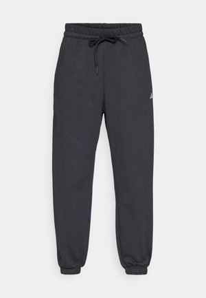 Szürke melegítőnadrág, elasztikus derékkal és állítható zsinórral. Cuffolt bokák és egy apró, diszkrét logó az oldalán. Puha anyagtextúra.