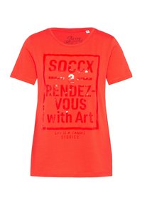 Czerwona bawełniana koszulka z krótkim rękawem, z okrągłym dekoltem, z błyszczącym nadrukiem graficznym z napisem "SOCCX a RENDEZ-VOUS with Art" w ramce prostokąta.
