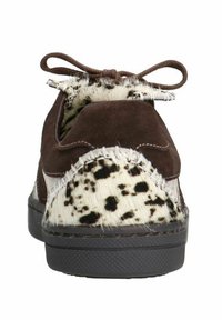 Baskets en suède marron avec un panneau en fourrure tacheté noir et blanc, dotées d'un système de laçage et de coutures contrastantes le long des bords.