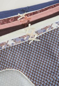 Cinq culottes pliées pour femmes avec une bordure en dentelle et de petits nœuds, présentant des motifs unis, cachemire et géométriques dans différentes couleurs.