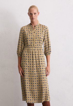 Geel patroon jurk met marineblauwe bloeiende motieven, kraag halslijn, geraffineerde taille en driekwart mouwen. Gladde stof, knie-lengte ontwerp.