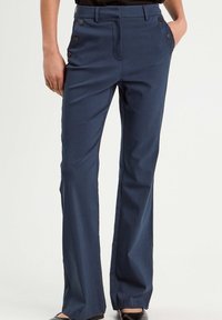 Dunkelblaues weit geschnittenes Hosen in einem glatten Stoff mit flachem Bund und seitlichen Knopf-Details. Verfügt über zwei frontale Taschen und eine maßgeschneiderte Passform.