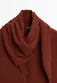 Rostfarbener Wollcardigan mit einem drapierten Schalkragen und schwarzen Knöpfen, ordentlich auf einem weißen Hintergrund gefaltet.