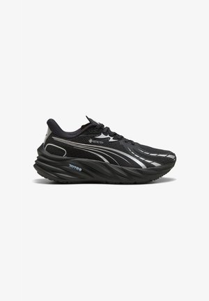 Black athletic shoe with a textured mesh upper, reflective accents, and a thick, curved sole. Features GORE-TEX and NITRO branding.