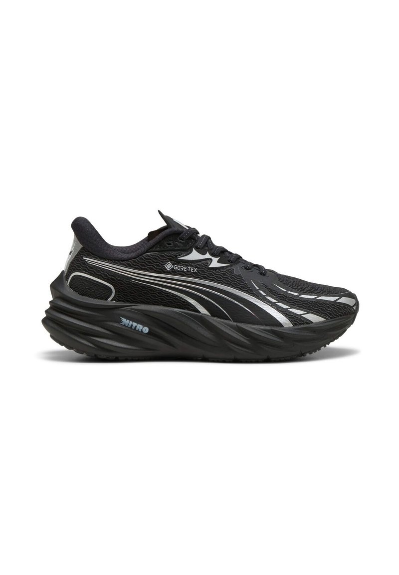 Zwarte sportieve schoen met een getextureerde mesh bovenkant, reflecterende accenten en een dikke, gebogen zool. Beschikt over GORE-TEX en NITRO merknaam.