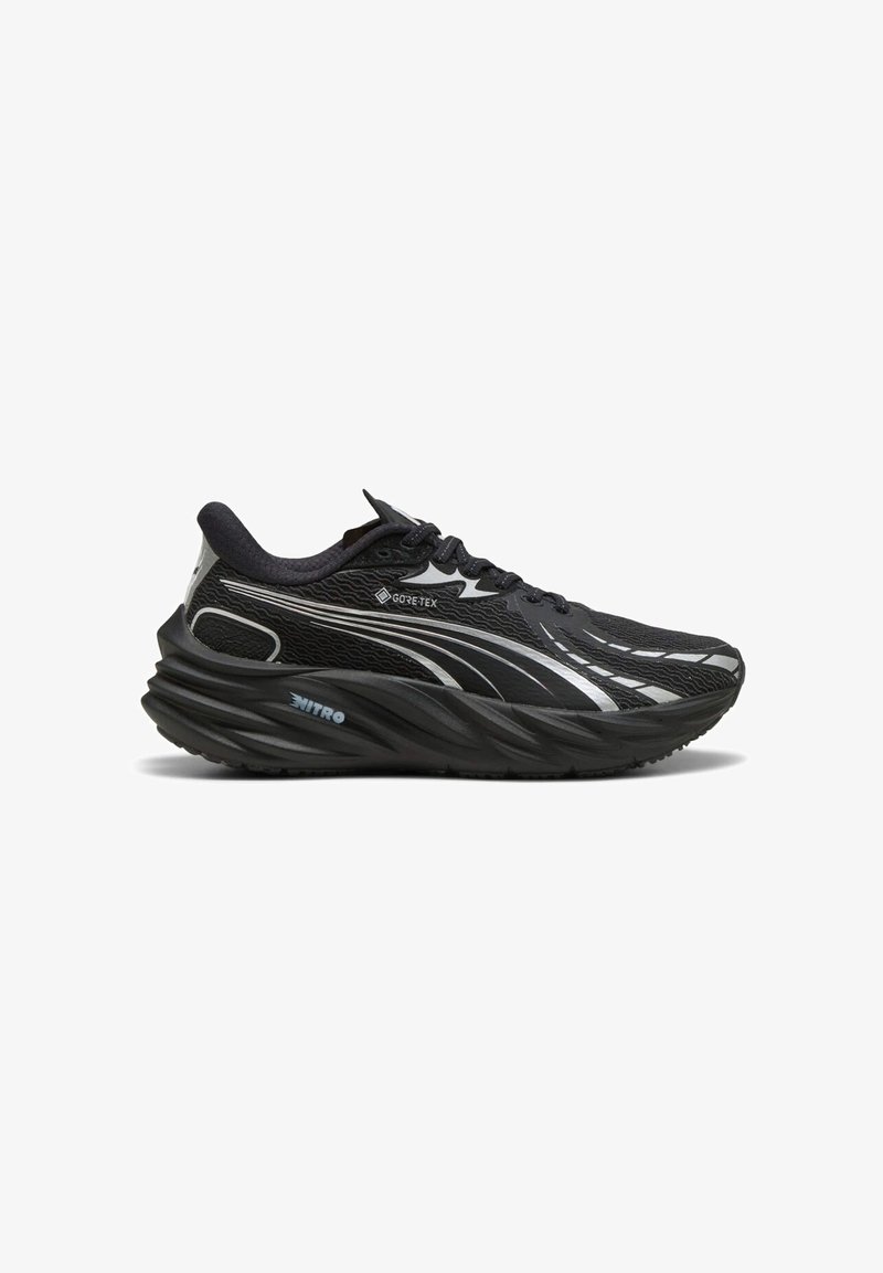 Czarne buty sportowe z teksturowaną siateczką na górze, odblaskowymi akcentami i grubą, zakrzywioną podeszwą. Zawierają branding GORE-TEX i NITRO.