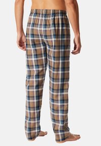 Geruite loungebroek in bruin, blauw en wit. Gemaakt van katoen, met elastische tailleband, ruime pasvorm en rechte pijpen. Zonder zakken.