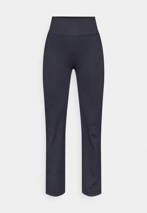 Leggings noirs extensibles avec une taille haute. Fabriqués en tissu lisse et doux, présentant une coupe ajustée et une coupe droite au niveau des jambes.