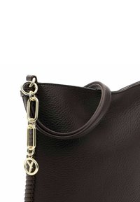 Brown leather tote bag with a textured finish, featuring a circular handle and a gold-toned chain accent.