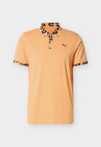 Polo pour homme couleur pêche avec col et bords de manches à motif floral noir, arborant un petit logo Puma sur le côté gauche de la poitrine.