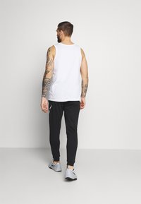 Nike Performance DRY TAPER - Pantalones deportivos - black/white