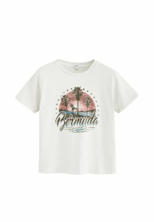 Weißes T-Shirt mit einem Sonnenuntergang, Palmen, Sternen und dem Text "Bermuda Unwind" auf der Vorderseite gedruckt.