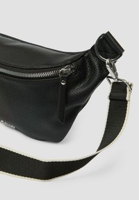 Schwarze Leder-Umhängetasche mit strukturiertem Oberflächen, silbernen Beschlägen, kontrastierendem Trageriemen mit weißen Akzenten und einer Reißverschluss-Fronttasche.