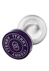 Vit kräm i en genomskinlig glasburk med ett lila lock. Locket har en cirkulär logotyp med vit text och en slät yta.
