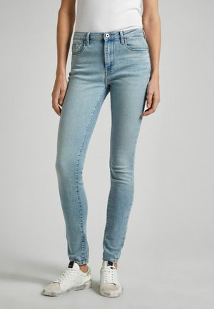 Ljust blå smala jeans i denim med hög midja, med en framficka, bakfickor och dragkedja. Bärs med vita sneakers.