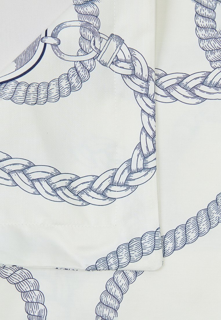 Ein weißer Stoff mit einem blauen Seil-Muster, verziert mit geflochtenen Akzenten und metallischen Hardware-Details, die in einem strukturierten Design angeordnet sind.