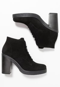 Botines negros de gamuza con diseño de cordones, tacón grueso texturizado y suela elevada con plataforma. Acabado suave con detalles de costuras sutiles.