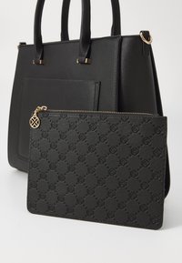 Black structured handbag with two handles, featuring a smooth texture. A smaller matching pouch with a raised pattern and gold zipper is included.